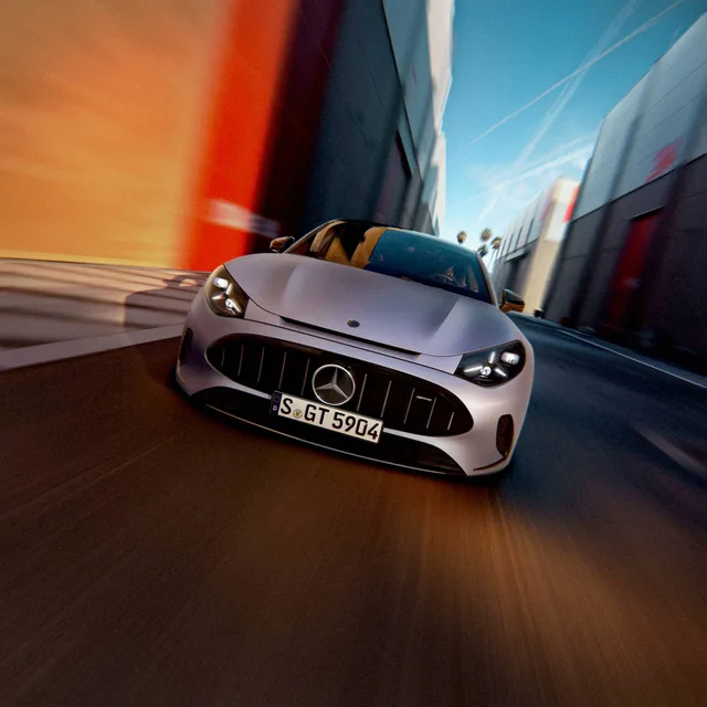 Sølvgrå Mercedes-AMG GT 53 4-dørs Coupé set forfra i fart på en bane