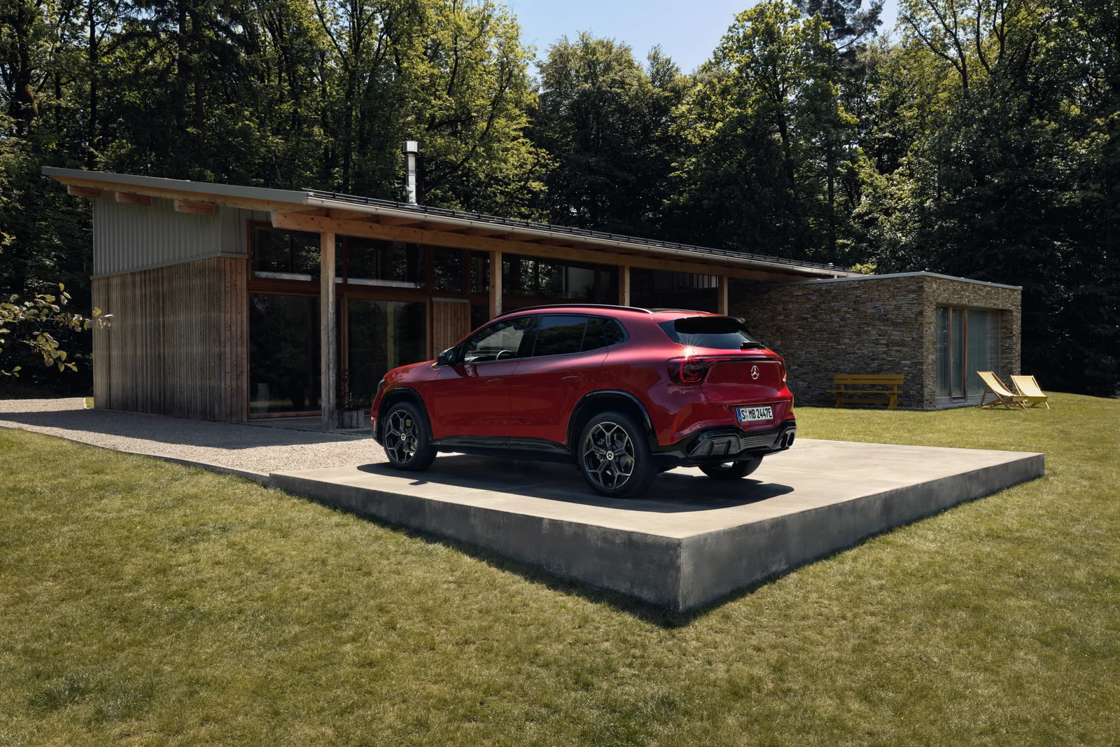 Ny Mercedes-Benz GLA electric i rød lak set skråt bagfra i landligt miljø. Foto: Mercedes-Benz AG.