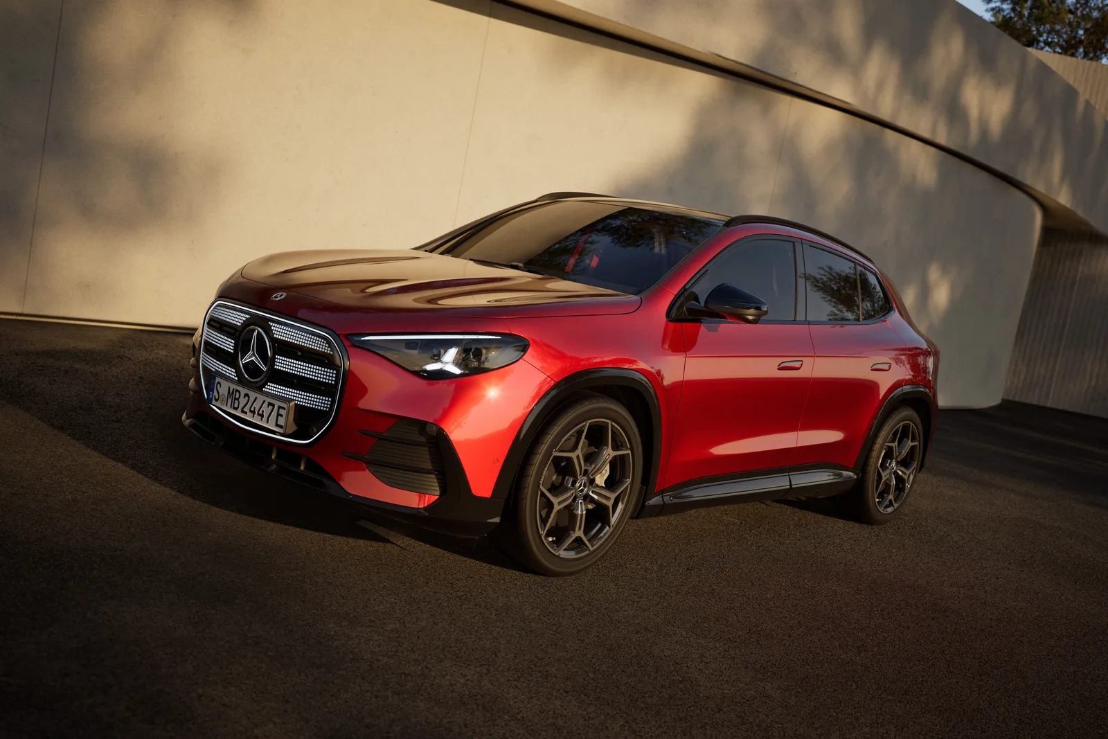 Ny Mercedes-Benz GLA electric i rød lak set skråt forfra med oplyst frontgrill. Foto: Mercedes-Benz AG.
