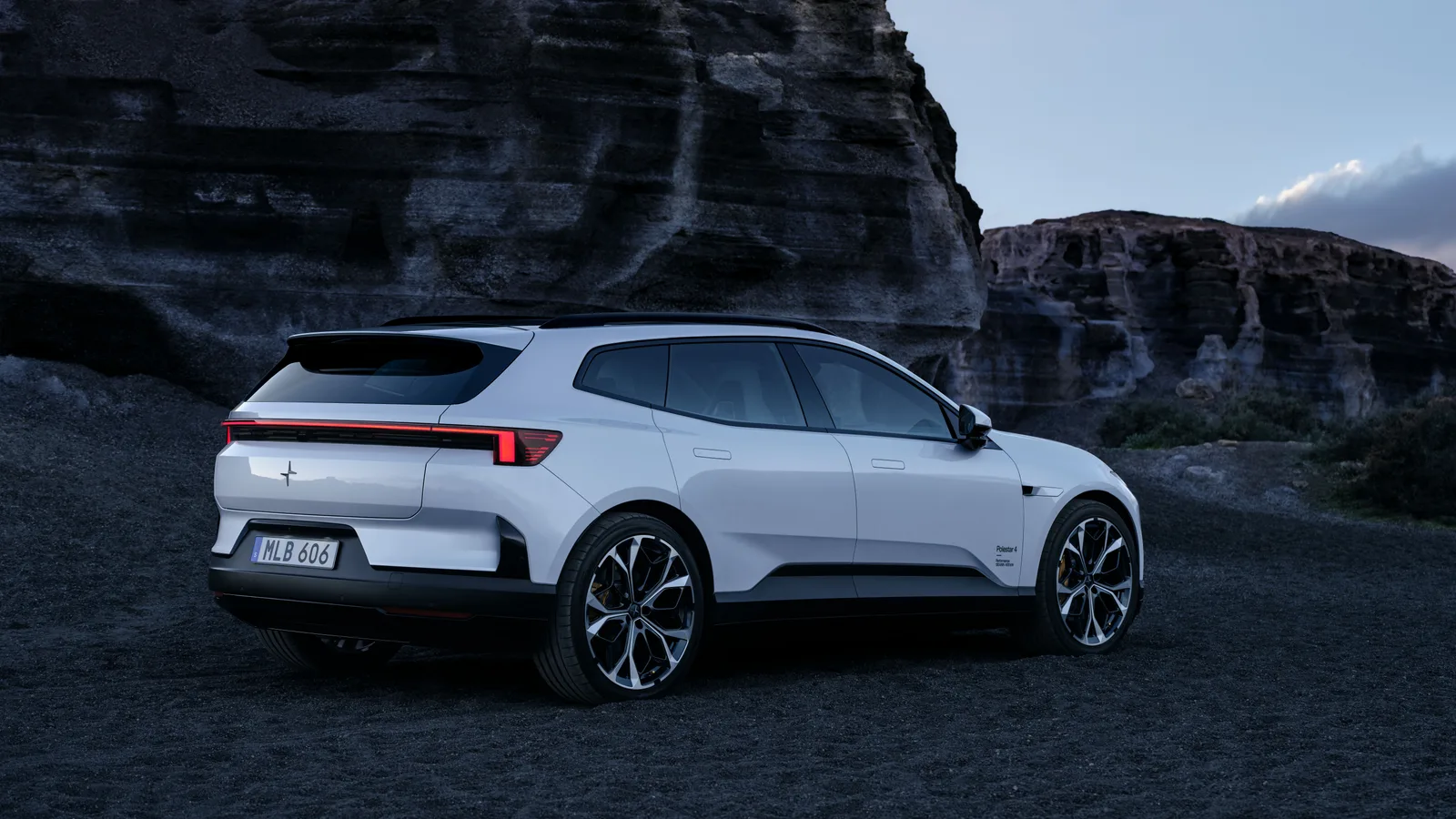 Polestar 4 SUV i hvid, set bagfra 3/4 i et vulkansk landskab. Officielt pressefoto fra Polestar.