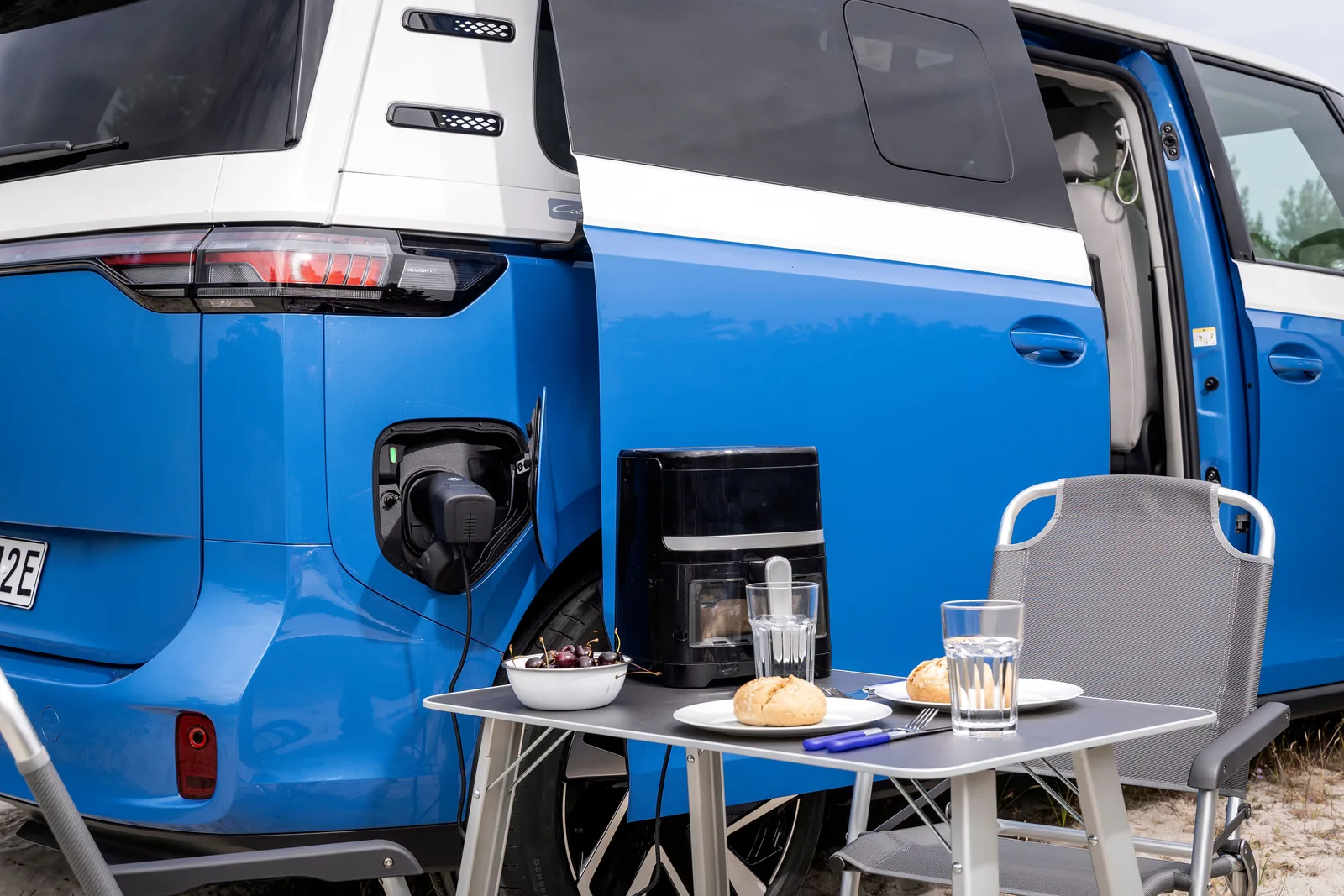 Åben bagklap på Volkswagen ID. California Cruise med campingbord, kaffemaskine og stole udenfor